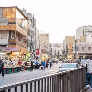 A street in Amman, Jordan, with market stalls, people, and cars