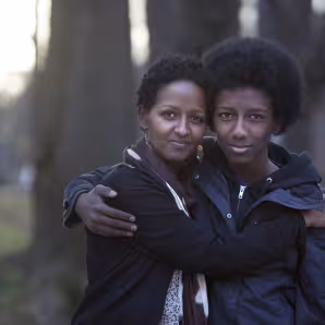 An Ethiopian resettled refugee mother and her son in the United States, where she works as a caseworker with other refugees