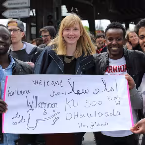 Four people stand with a sign at a demonstration