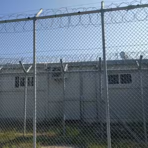 Buildings behind a barbed wire fence