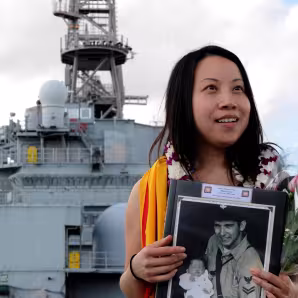 A woman stands onboard the U.S. Navy vessel on which she was born.