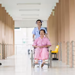 A nurse assists a woman in a wheelchair