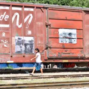 A woman walks alongside a train in Mexico.