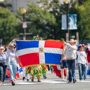 People carry the flag of the Dominican Republic at a parade in Washington, DC.