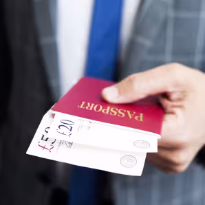 A man presents cash inside a passport