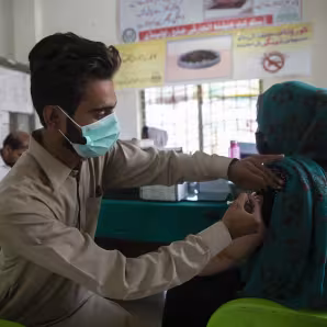 An Afghan refugee receives a COVID-19 vaccination in Pakistan.