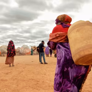 A displaced woman walks with a jerrycan of water in Somalia.