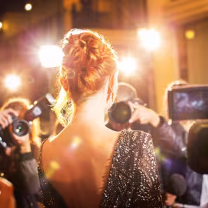 A female celebrity being photographed at an event.
