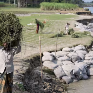A man walks through a community affected by river erosion in Bangladesh.