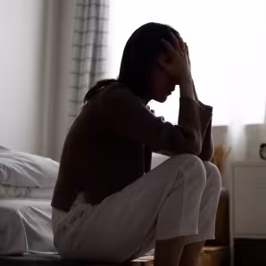 A woman crying in her room.