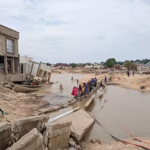 People walk through floodwaters in Nigeria.