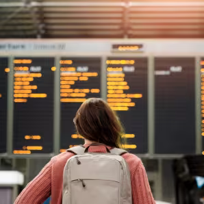A woman at an airport looks at flight information