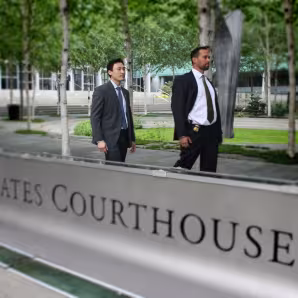 U.S. immigration officials walk by a courthouse in Seattle.