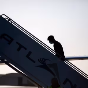 A man boards a repatriation charter flight to Guatemala.