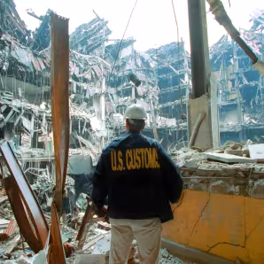 A U.S. Customs agent looks at wreckage following the 9/11 terror attacks