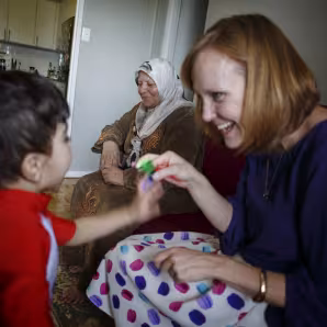 A private refugee sponsor in Canada plays with a boy.