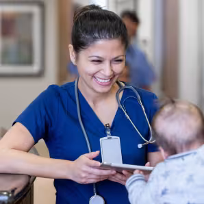 A nurse looks at a baby.