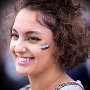 A young woman with the Syrian flag painted on her cheek