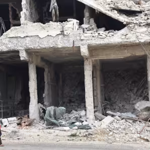 A child walks by a destroyed building in Syria. 