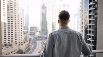 The back of a man looking out at a city