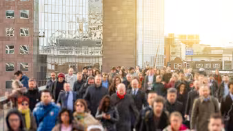 A crowd of people walking across London Bridge