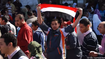 A young Egyptian protester holding an Egyptian flag, Cairo, Egypt