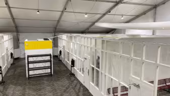 A series of empty white detention spaces