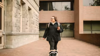 Photo of woman walking around a school campus.
