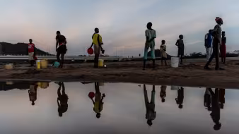 Photo of a group of women collecting water from a riverbed in Kenya