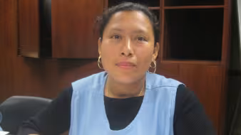 Woman in blue smock sitting at table