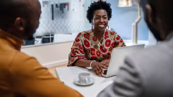 A Black female financial advisor in a meeting.
