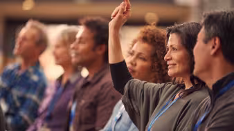 Woman raises hand to ask question in classroom