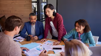 Male and female business professionals gathered at a conference table