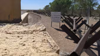 Fencing and a "no trespassing" sign at the U.S.-Mexico border