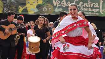 Migrants and natives dance at a multicultural celebration in La Vega, Chile.