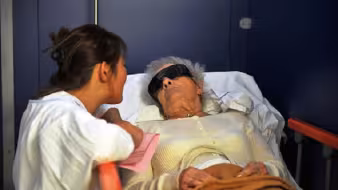 Asian healthcare worker helps patient in European hospital 