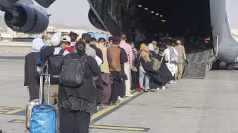 Evacuees prepare to board a C-17 at Hamid Karzai International Airport, Afghanistan