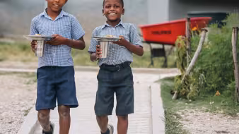 Haitian school children walking down a sidewalk