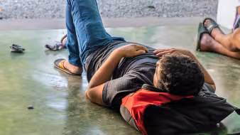 Central American migrant resting at Casa del Migrante in Tecun Uman, Guatemala