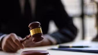Hand holding a judge's gavel