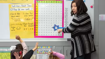 Teacher providing instruction in early childhood classroom
