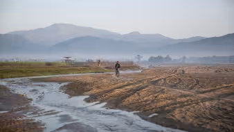 Drying riverbed in landscape with mountains in the distance