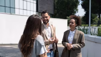 3 people in conversation on the street