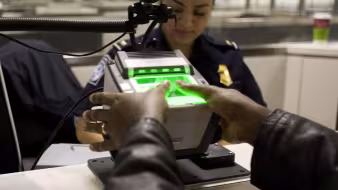 A traveler arriving at Washington Dulles International Airport Monday uses the new US-VISIT mechanism that records all 10 fingerprint images. (Gerald L. Nino/CPB)