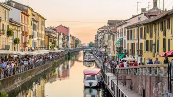 Crowds of people walk along the canal in Milan