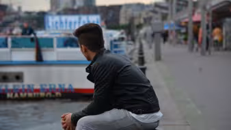 A refugee looks out over Hamburg harbor