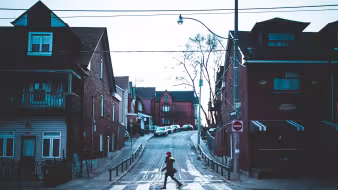 Woman walks across a street in a Toronto neighborhood
