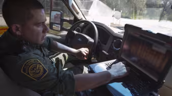 South Texas Border Patrol agent inspects a truck at a CBP checkpoint.