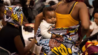 Mother and child at a local refugee art auction & fashion show.