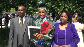 A refugee student with his family at graduation.